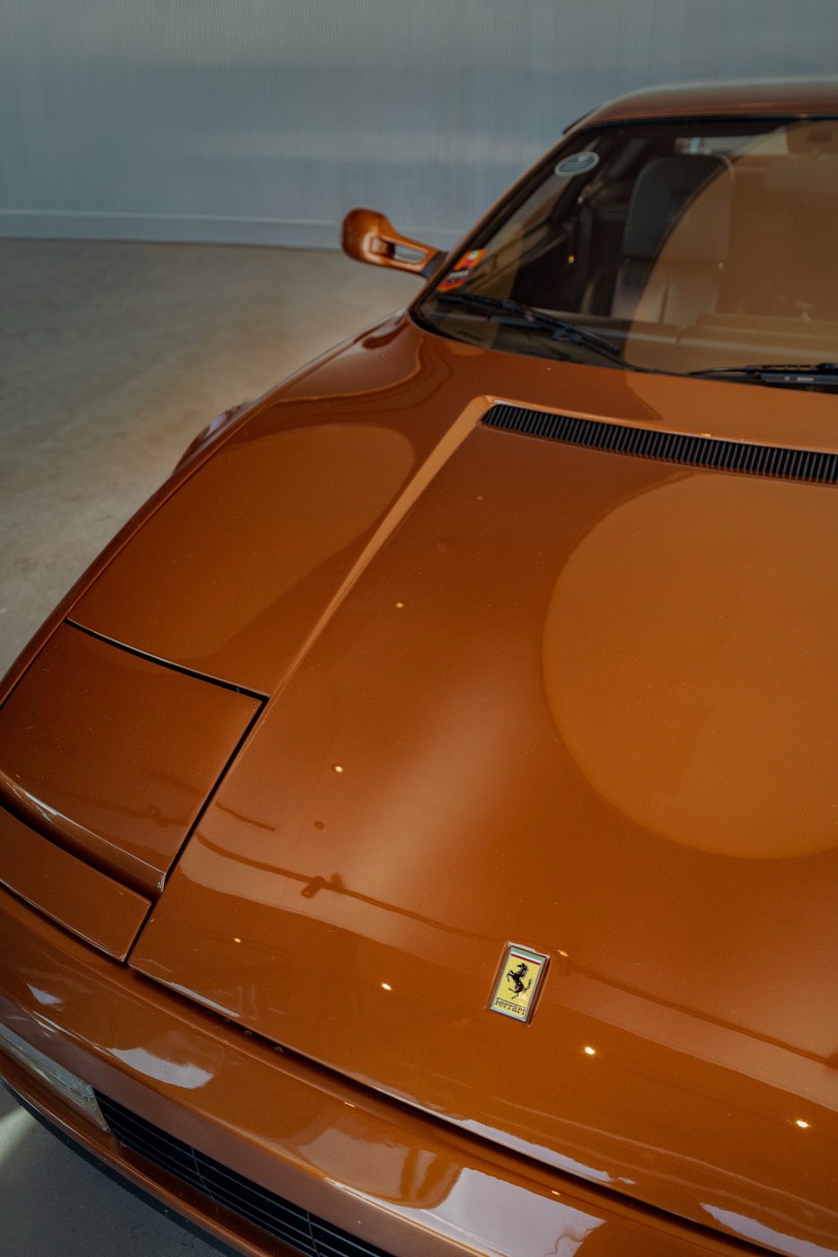 Bonnet and badge of a classic Ferrari in copper paint