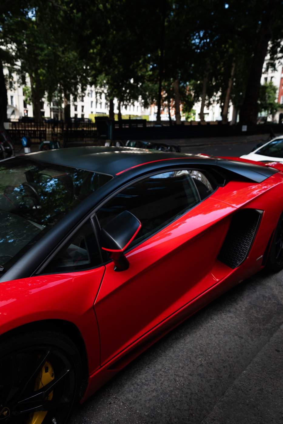 Side profile of a red Lamborghini Aventador SVJ with matte black roof